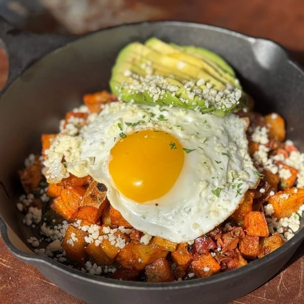 Bungalow Heights' breakfast skillet with fried egg, avocado, sweet potatoes, and crumbled cheese.